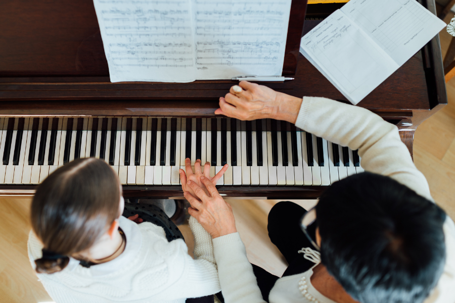 young woman taking a piano lesson after learning how to find a piano teacher