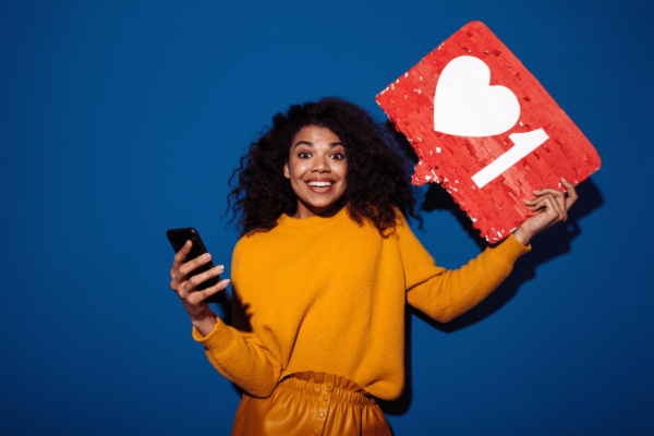 a woman holding a phone and an instagram like sign