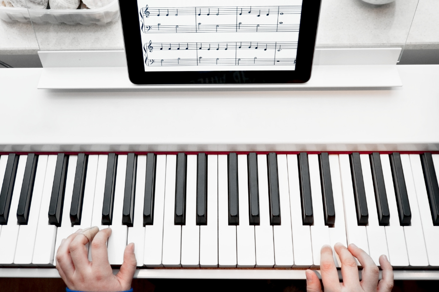 hands playing a piano with digital music from tomplay sheet music subscription
