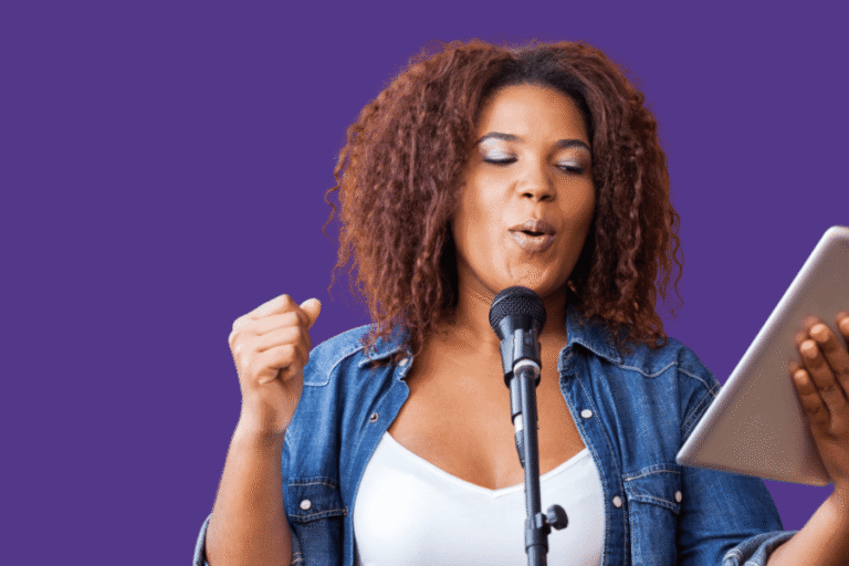 a woman in a jean jacket holding an iPad and doing her daily vocal routine into a microphone